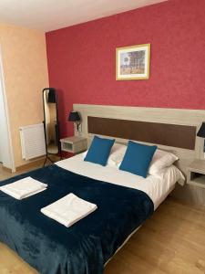 una camera da letto con un grande letto con cuscini blu di Auberge du pont canal a Briare