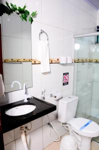 uma casa de banho com um WC, um lavatório e um espelho. em Pousada Chalés do Toque em São Miguel dos Milagres