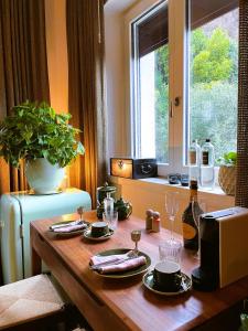a wooden table with plates and wine glasses on it at Villa Lou in Toscolano Maderno