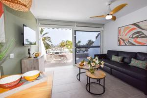een woonkamer met een bank en een tafel bij Book Jet - Casa Adam BEACH & WIFI in Morro del Jable