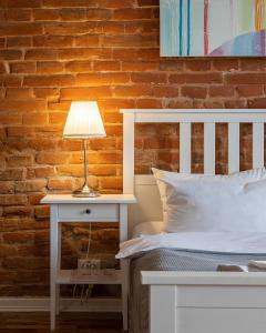 uma cama com uma mesa de cabeceira branca com um candeeiro em Danylo Inn em Lviv