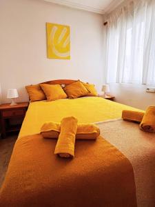 Un dormitorio con dos toallas en una cama. en Yellow Apartment-La Mata -2 min to beach, private garage, en La Mata
