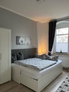 um quarto com uma cama num quarto com uma janela em Gästewohnung zum Heiligen Grund em Meissen