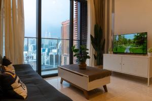 un salon avec un canapé et une grande fenêtre dans l'établissement Lalaport Suites At Lucentia Bukit Bintang City Center, à Kuala Lumpur