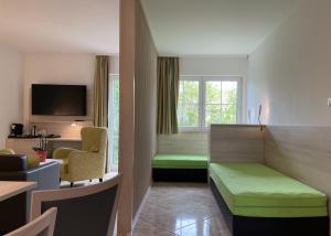 Habitación de hotel con cama, sofá y ventana en Flair Seehotel Zielow en Ludorf