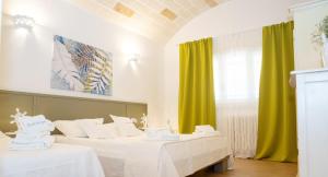 a room with two beds and green curtains at Trullo dei Sogni con Piscina e Jacuzzi in San Michele Salentino +38 photos