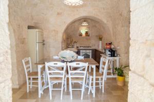a kitchen with a table and chairs in a room at Trullo dei Sogni con Piscina e Jacuzzi in San Michele Salentino
