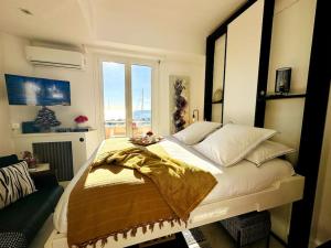 een slaapkamer met een groot bed en een groot raam bij Studio VUE MER IMPRENABLE PLEIN SUD à GOLFE JUAN in Vallauris