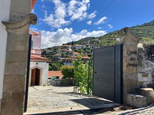 a gate to a house with a mountain in the background at casa das ameias in Folgosa