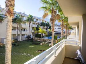 um apartamento com varanda com palmeiras e uma piscina em Immaculate 2-Bed Apartment in Pego em Pego