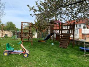 un patio con un parque infantil con un balancín y una zona de juegos en Ferienwohnung Pölkentor, en Quedlinburg