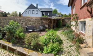un patio trasero con una pared de piedra y un patio en Ferienwohnung Pölkentor, en Quedlinburg