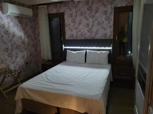 Terrace Urla في أورلا: غرفة نوم صغيرة مع سرير مع ملاءات بيضاء