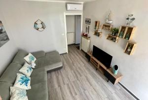 a living room with a couch and a flat screen tv at Brezza Marina in Diano Marina