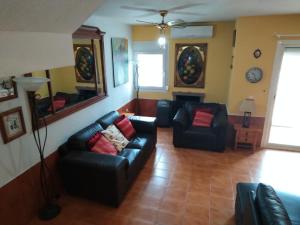 a living room with two black leather couches at Lamedos in San Luis de Sabinillas