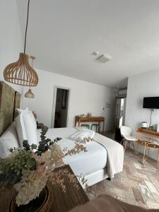 ein Schlafzimmer mit einem weißen Bett mit Blumen darauf in der Unterkunft Casapuerta El Refugio in Zahara de los Atunes