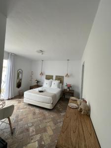 1 dormitorio con cama blanca y mesa de madera en Casapuerta El Refugio en Zahara de los Atunes