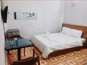 um quarto com uma cama, uma mesa e uma secretária em Hien CoCo Homestay Hoi An em Hoi An