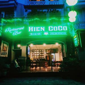 um restaurante com um letreiro verde de néon em frente em Hien CoCo Homestay Hoi An em Hoi An