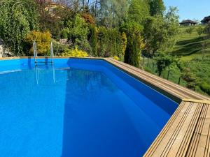 una piscina de agua azul y una terraza de madera en Villa Marlena en Spytkowice