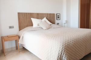a bedroom with a white bed with a wooden headboard at La Resina 3BD 2 BTH - SUN&RELAX in Estepona +27 photos