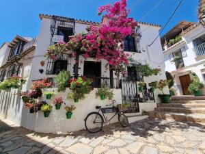 a bike parked in front of a building with flowers at La Resina 3BD 2 BTH - SUN&RELAX in Estepona