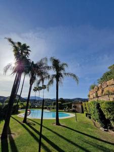a group of palm trees next to a swimming pool at La Resina 3BD 2 BTH - SUN&RELAX in Estepona