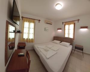 um quarto com uma grande cama branca e uma mesa em Hotel Gulec em Bodrum City