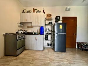 a kitchen with a refrigerator and a stove at The Pine Lush Hideout in Baguio