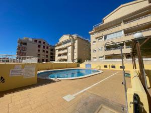 a swimming pool in the middle of some buildings at Apartamentos Canet de Berenguer 3000 in Canet de Berenguer