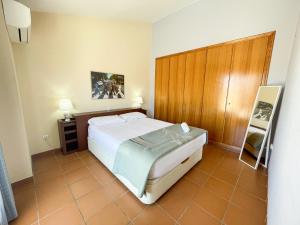 カネット・デ・ベレンゲルにあるApartamentos Canet de Berenguer 3000のベッドルーム1室(ベッド1台付)、木製キャビネットが備わります。