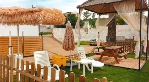 un patio con sillas, una mesa y una sombrilla en Tu Casa Rural, en Castilblanco de los Arroyos