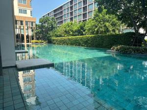 a swimming pool in the middle of a building at Baan Koo Kiang Hua Hin คอนโดบ้านคู่เคียง หัวหิน in Hua Hin