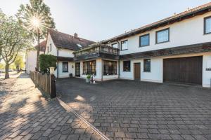 a large white house with a brick driveway at Pension Heinrich Heine in Lutherstadt Wittenberg