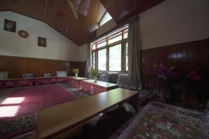 a living room with a couch and a table at Ramta Jogi Hotel & Stays in Manāli