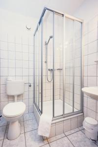 a bathroom with a shower and a toilet and a sink at Pension Heinrich Heine in Lutherstadt Wittenberg