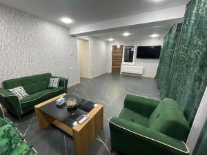 sala de estar con 2 sillas verdes y mesa en Dream Home, en Vanadzor