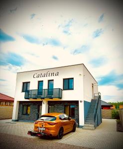 an orange car parked in front of a building at Apartmány Catalina in Nesvady