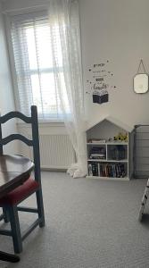 a room with a chair and a book shelf at Two bedroom ground floor apartment with garden in Falkirk
