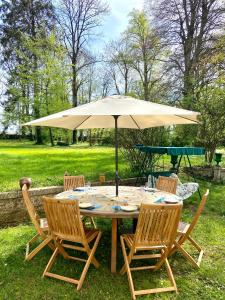 une table avec un parasol dans l'herbe dans l'établissement Grande et belle demeure, à Prez-sous-Lafauche