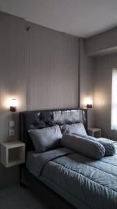 a bedroom with a large bed with two night stands at Apt m34 square by kiiw in Bandung