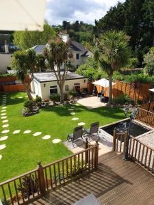 a view of a yard with palm trees and a deck at Appletorre House Holiday Flats in Torquay