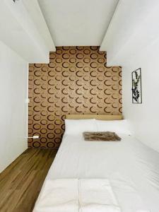- une chambre avec un lit blanc et une tête de lit en bois dans l'établissement WV 10 Stylish 1BR Apartment, à Iloilo