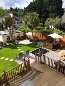 a wooden deck with chairs and umbrellas in a yard at Appletorre House Holiday Flats in Torquay