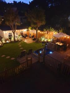 a backyard at night with a pool and palm trees at Appletorre House Holiday Flats in Torquay