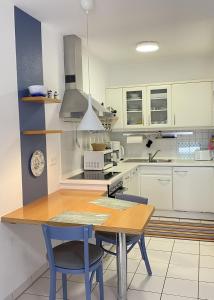 una cucina con armadi bianchi e tavolo e sedie in legno di Haus Claudia a Zingst