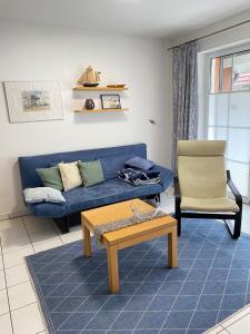 a living room with a blue couch and a chair at Haus Claudia in Zingst