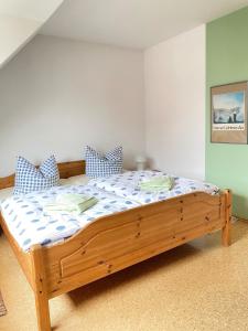 a bedroom with a wooden bed with blue and white sheets at Haus Claudia in Zingst