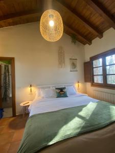 a bedroom with a large bed and two chandeliers at Molino del Corregidor in San Román de Cameros