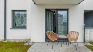 three chairs and a table in front of a house at Morelowa, Sun & Snow in Władysławowo